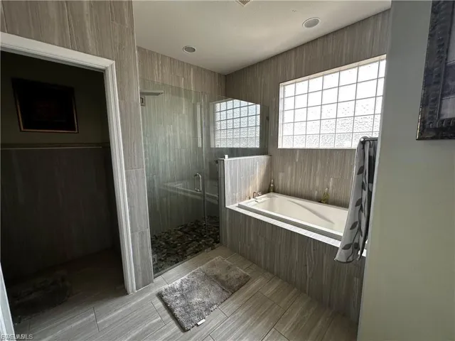 Full bath with a shower stall and a garden tub