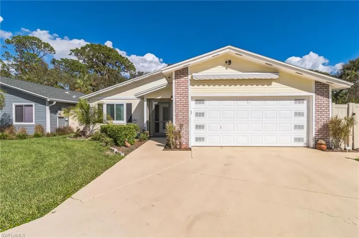 Ranch-style home featuring a garage and a front lawn