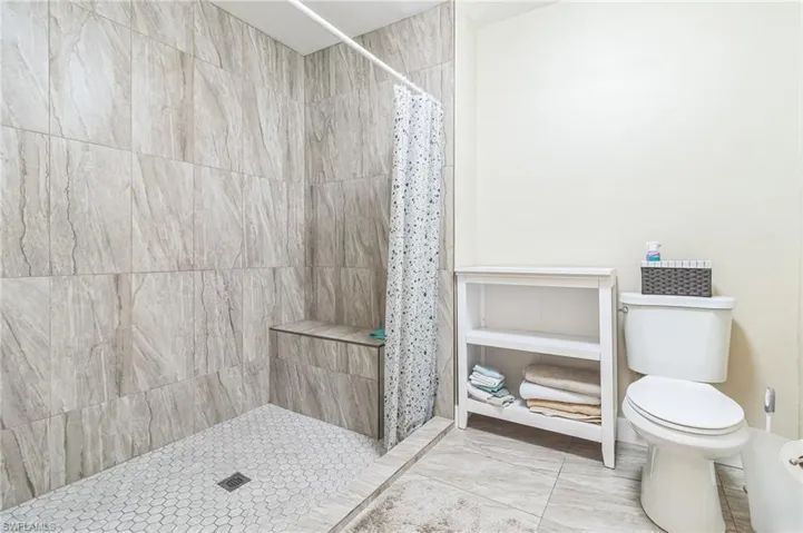 Bathroom featuring curtained shower and toilet