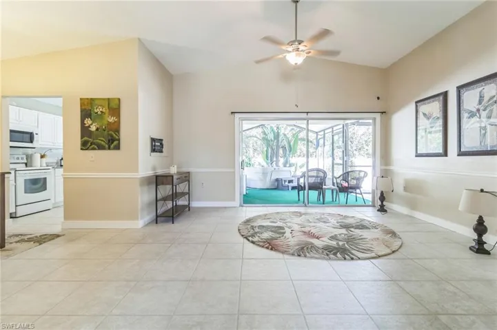 Tiled dining area with ceiling fan and lofted ceiling