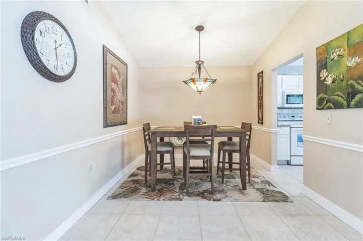 Dining space featuring light tile patterned floors and vaulted ceiling
