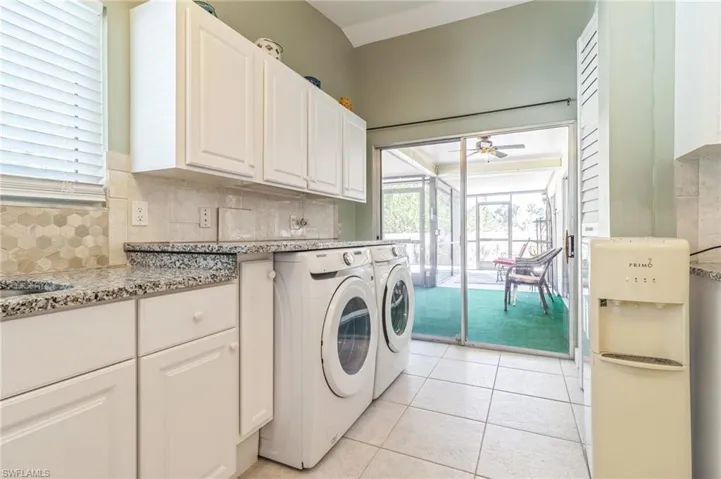 Laundry area featuring cabinets, a wealth of natural light, ceiling fan, and light tile patterned floors