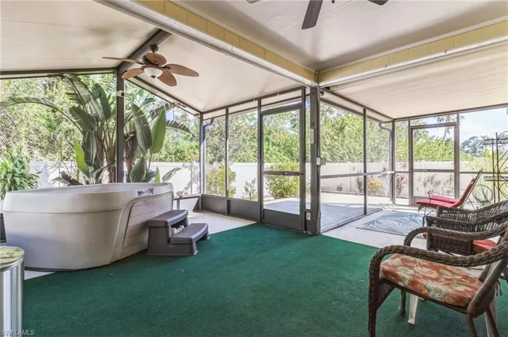 Sunroom with lofted ceiling with beams, a jacuzzi, and ceiling fan