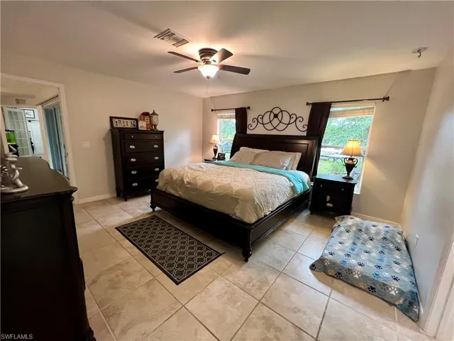 Primary bedroom featuring ceiling fan and tile floors.