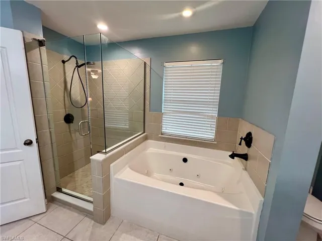 Jetted tub and separate frameless glass enclosed shower.