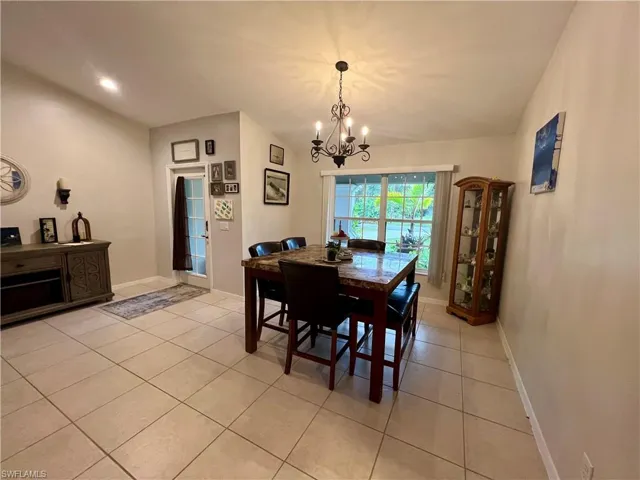 Tiled dining room with cathedral ceilings and a notable chandelier