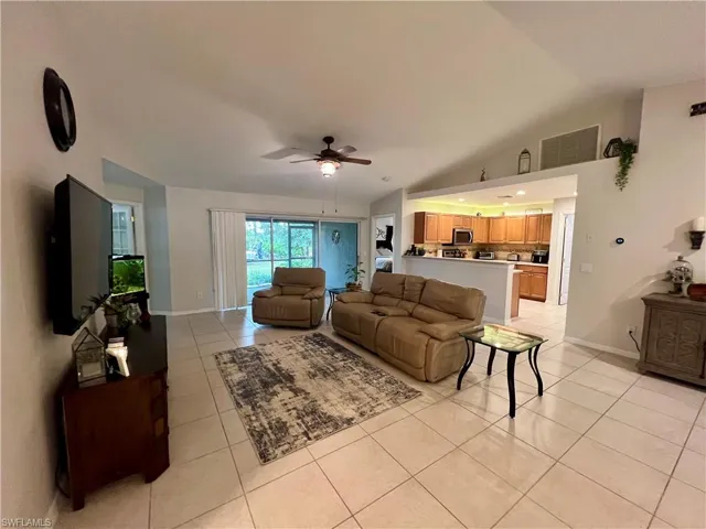 Tiled living room with cathedral ceilings and ceiling fan