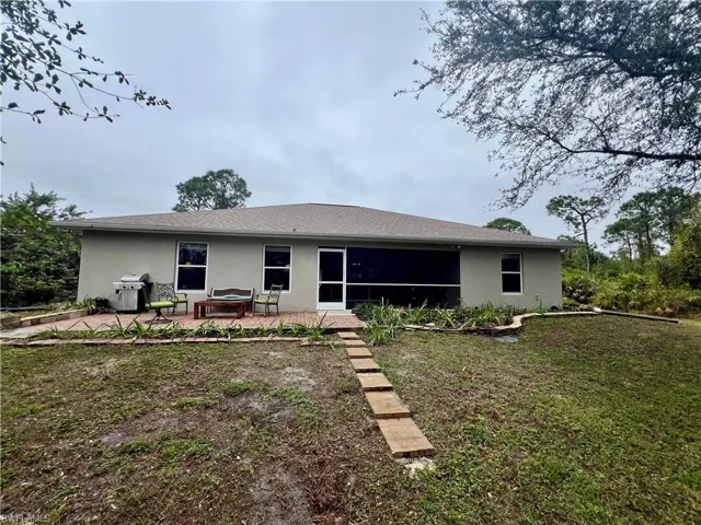 Back of property featuring a patio area and a yard