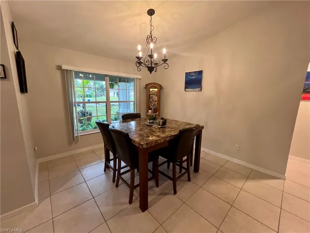 Dining room featuring light tile patterned floors and an inviting chandelier