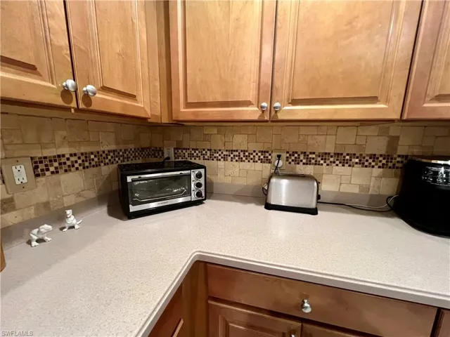 Kitchen featuring tasteful stone tile backsplash