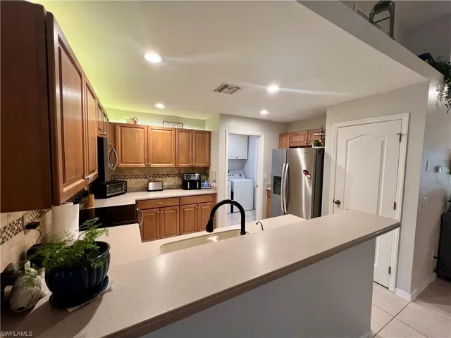 Kitchen with breakfast bar and lighting on tops of cabinets.