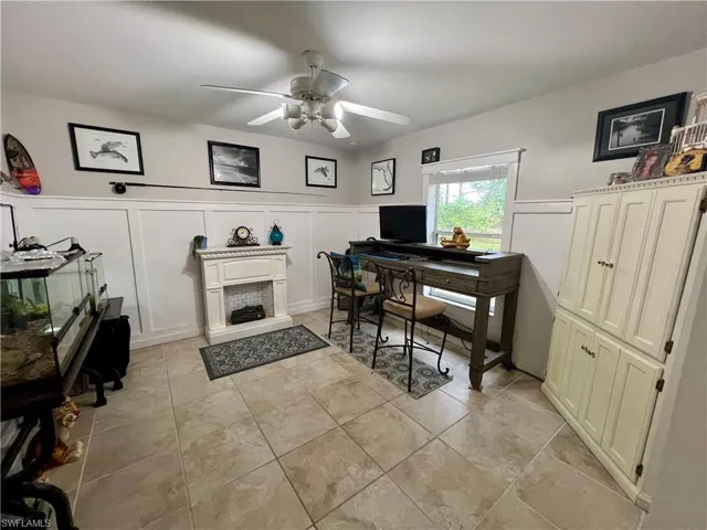 Home office with ceiling fan and decorative molding.