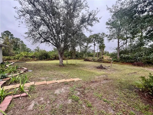 Spacious backyard with an oak tree for shade.