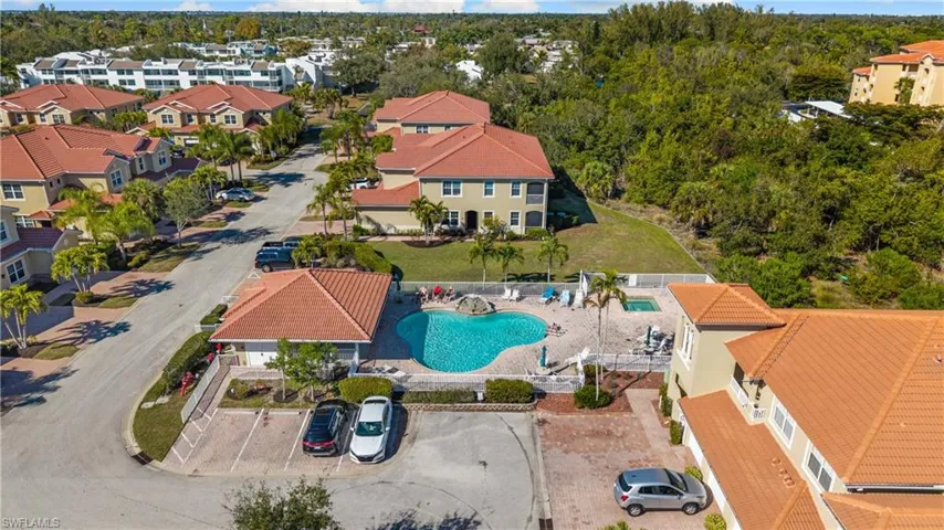 Community pool area with a curvilinear swimming pool, integrated spa, and surrounding paver deck