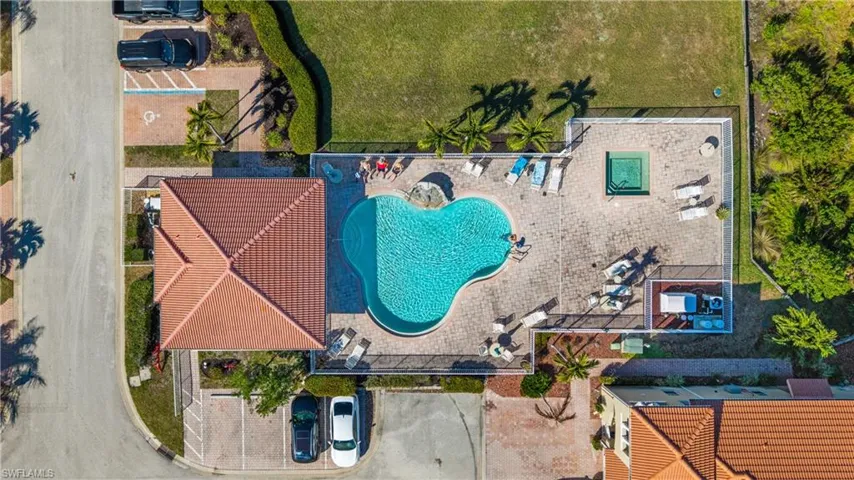 Resort-style pool area featuring a freeform swimming pool, integrated spa, and expansive paver deck