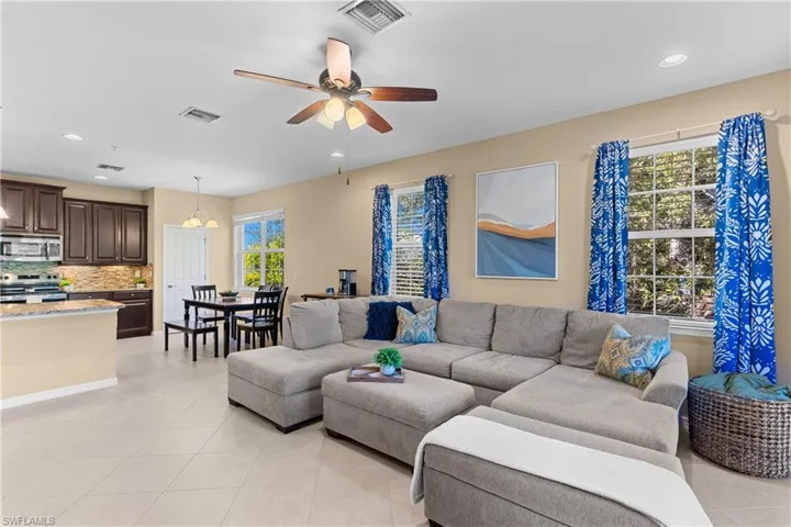 Open-concept living space featuring light-toned tile flooring and recessed lighting