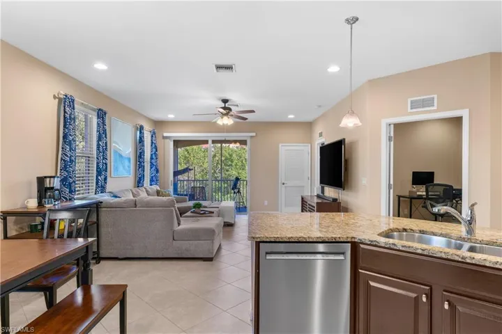 Open-concept living area with tile flooring and recessed lighting