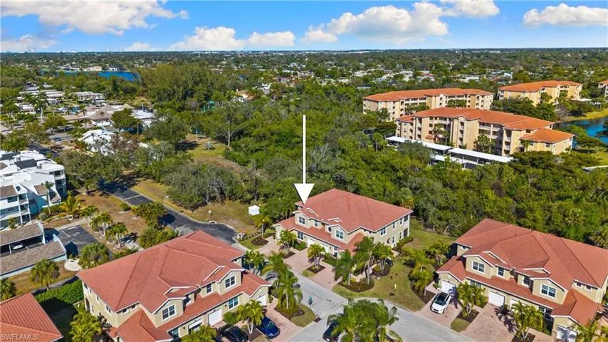 Aerial perspective showcasing a multi-story residential building with a terracotta-style tiled roof and multiple dormer windows