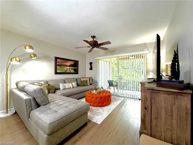 Living area with light wood-type flooring and a ceiling fan