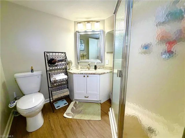 Bathroom featuring a stall shower, vanity, and light wood finished floors