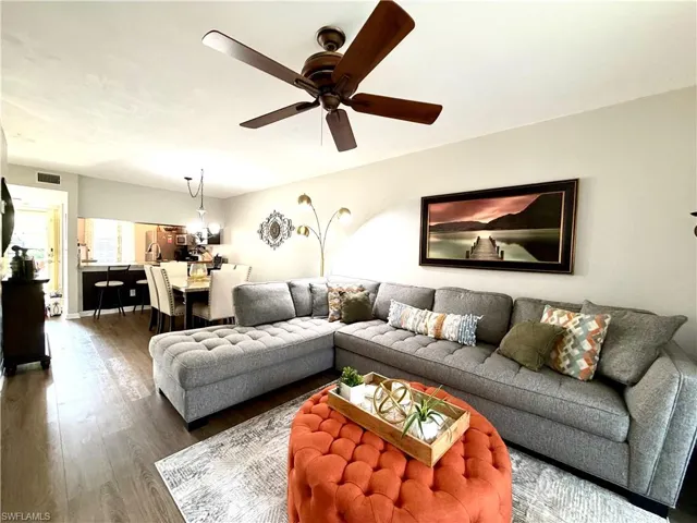 Living room with dark wood-style floors and ceiling fan