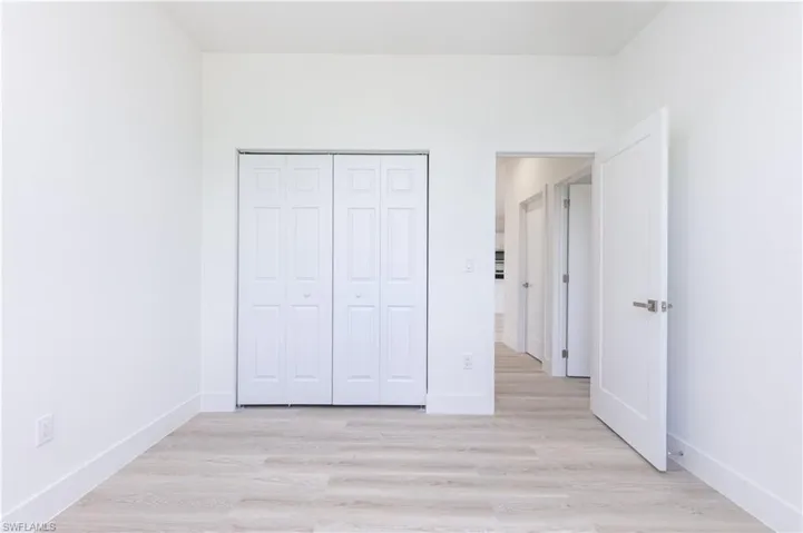 Unfurnished bedroom featuring a closet and light wood-type flooring