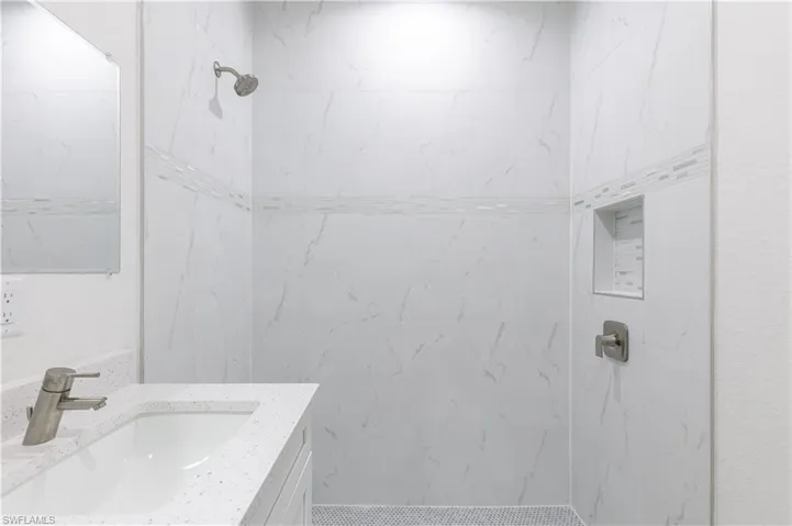 Bathroom featuring tiled shower and oversized vanity