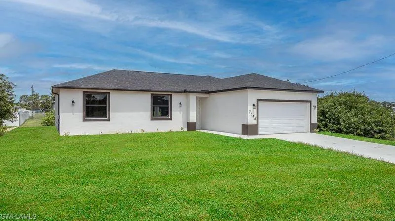 Ranch-style house with a garage and a front yard