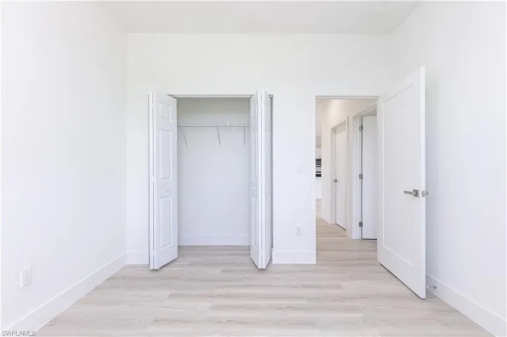 Unfurnished bedroom with a closet and light hardwood / wood-style floors