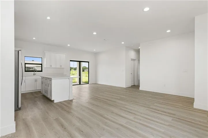 Unfurnished living room with sink and light hardwood / wood-style flooring