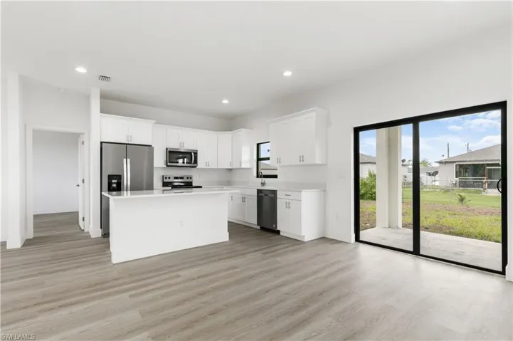 Kitchen with stainless steel appliances, plenty of natural light, and light hardwood / wood-style floors