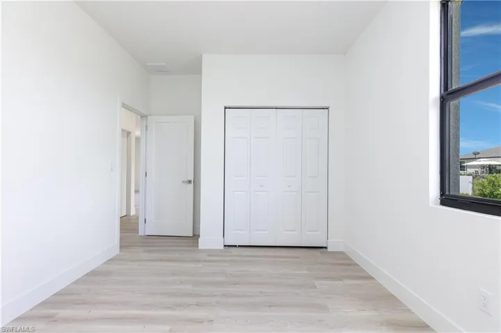 Unfurnished bedroom with a closet and light hardwood / wood-style floors
