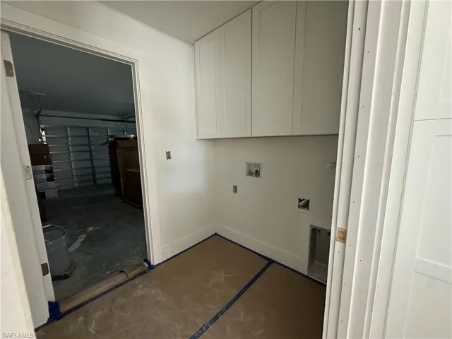 Utility space featuring white shaker-style wall cabinetry and dedicated plumbing hookups