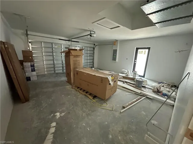 Attached garage featuring a concrete floor, motorized sectional garage door, and a separate exterior entry door
