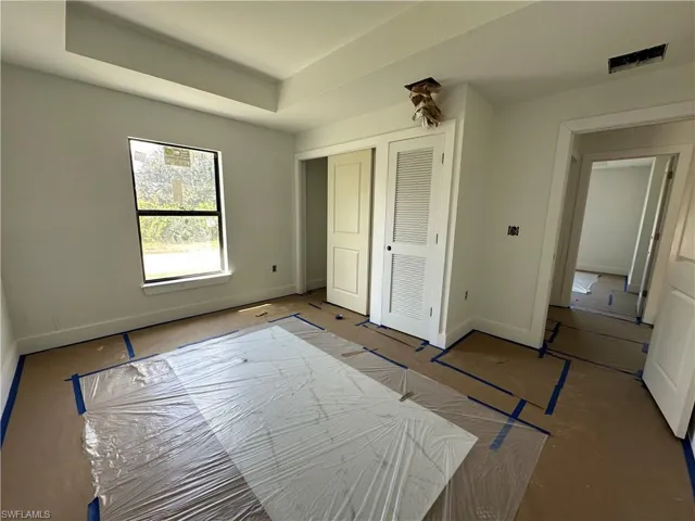 Tray ceiling, single-hung window with casing, and closet with louvered door