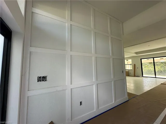 Floor-to-ceiling grid wall paneling, high ceilings, large-format window groupings, and sliding glass doors