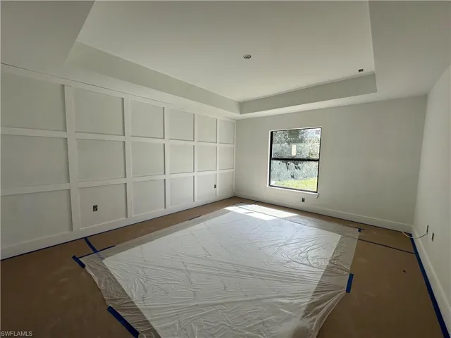 Interior space featuring custom wall molding, a tray ceiling, and a singular picture window