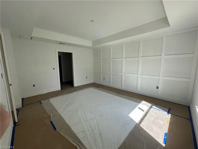 Room featuring a tray ceiling and white square-paneled wall molding