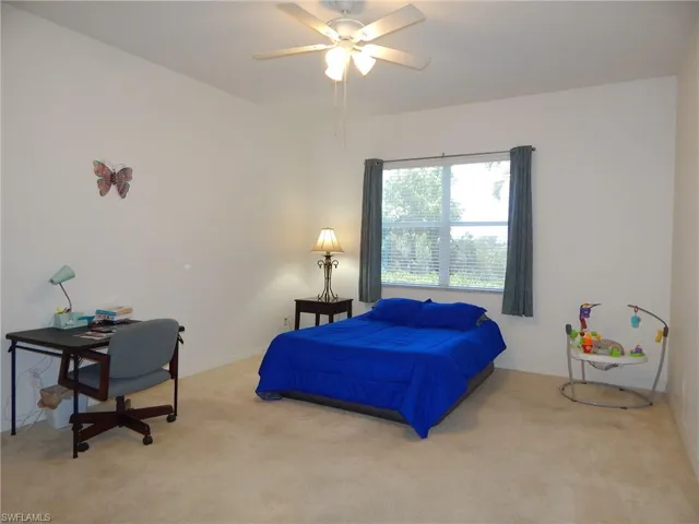Carpeted bedroom featuring ceiling fan