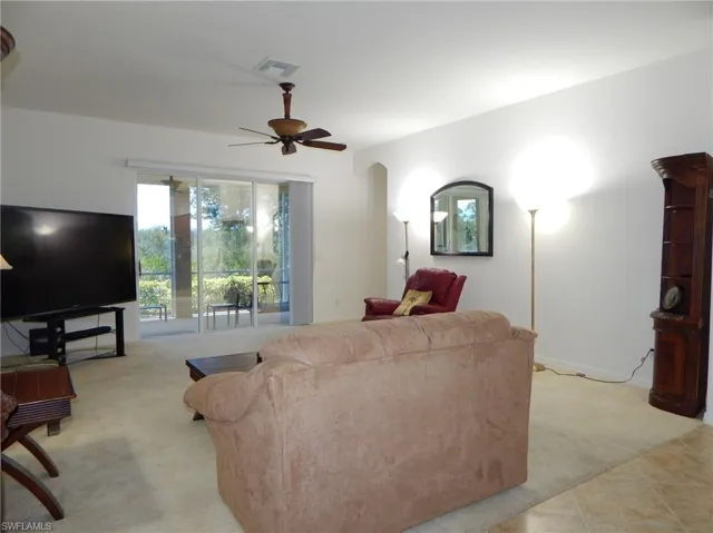Living room featuring ceiling fan and light tile floors