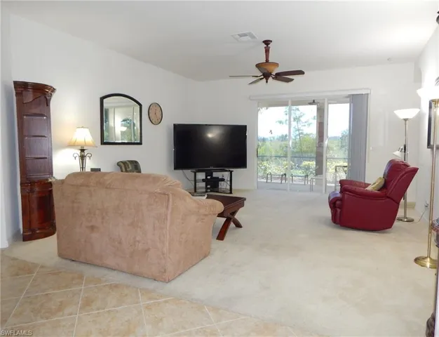 Carpeted living room featuring ceiling fan