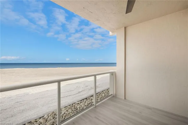 Balcony featuring view of water and beach