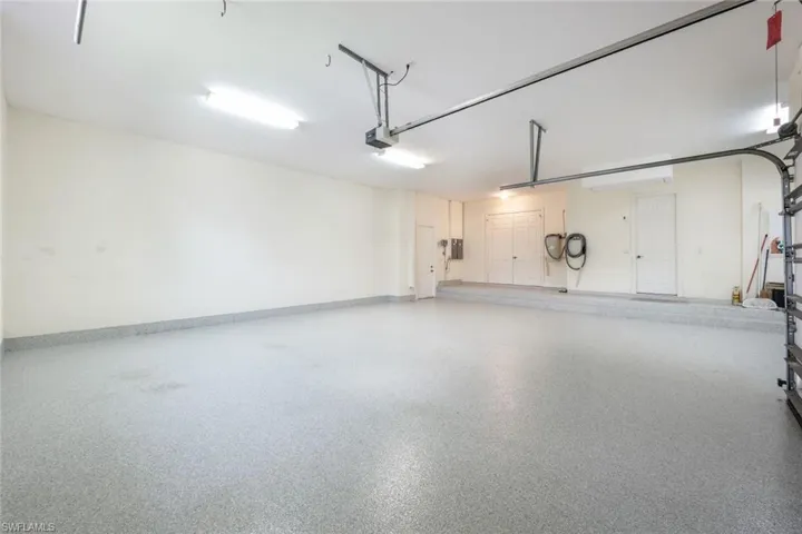 Garage featuring electric panel and a garage door opener
