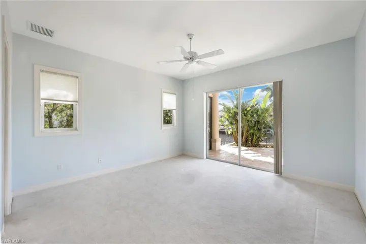 guest bedroom featuring ceiling fan, a healthy amount of sunlight, and light carpet