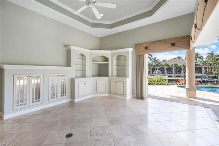 Unfurnished living room with ceiling fan, a wealth of natural light, and light tile patterned floors