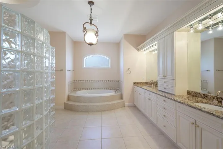 Bathroom featuring double vanity, a bath, and tile patterned flooring