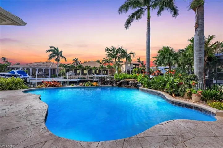 Pool at dusk featuring a patio