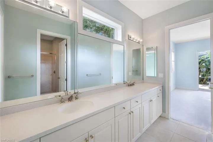 Bathroom featuring dual bowl vanity and tile patterned flooring