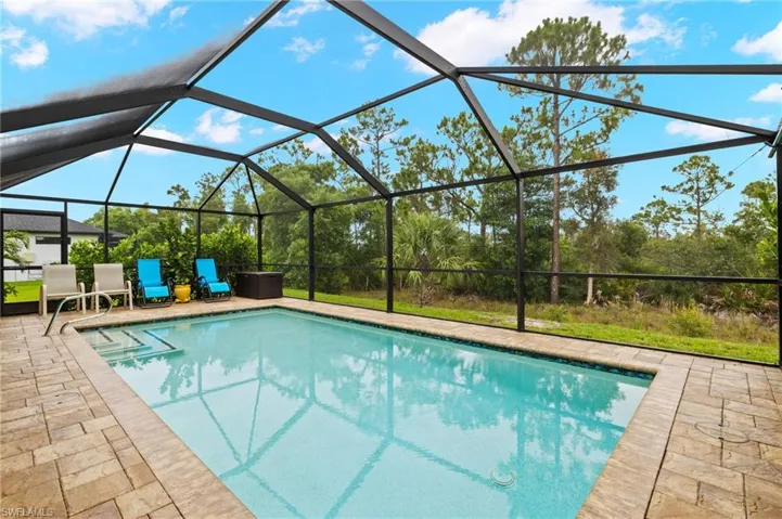 Large pool is screened in and has a large wooded lot behind it offering lots of privacy.