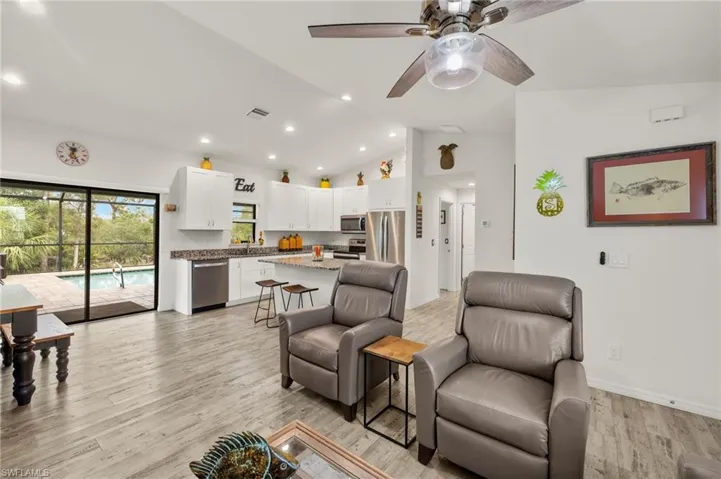 Light and bright open living area features LVT flooring and cathedral ceilings